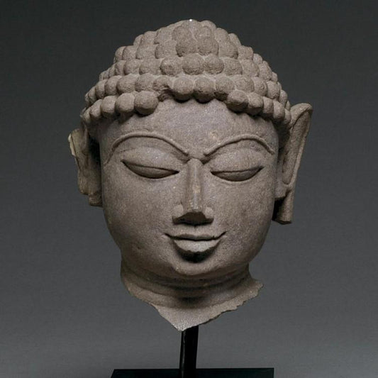 A mottled red sandstone head of a Jina, India, 11th/12th century CE