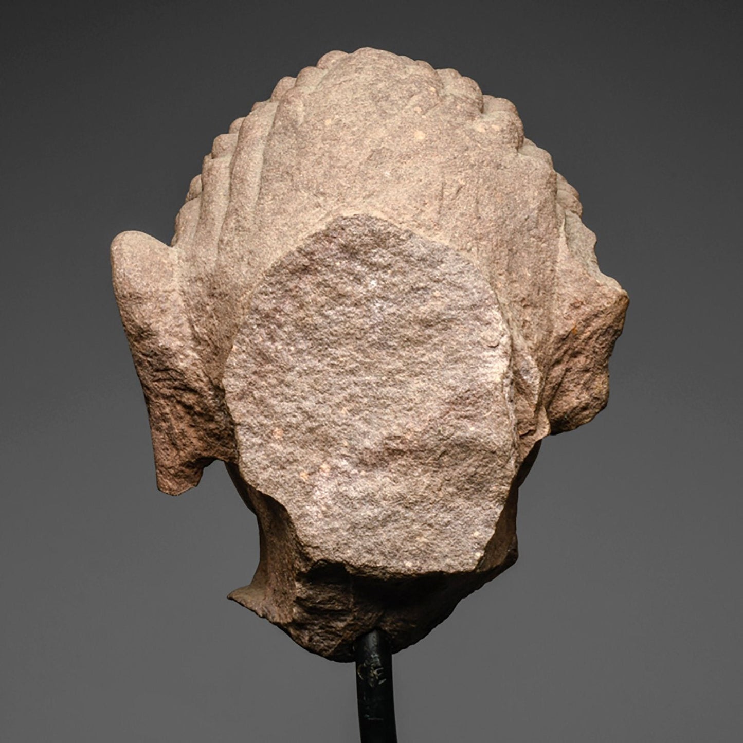 A mottled red sandstone head of a Jina, India, 11th/12th century CE