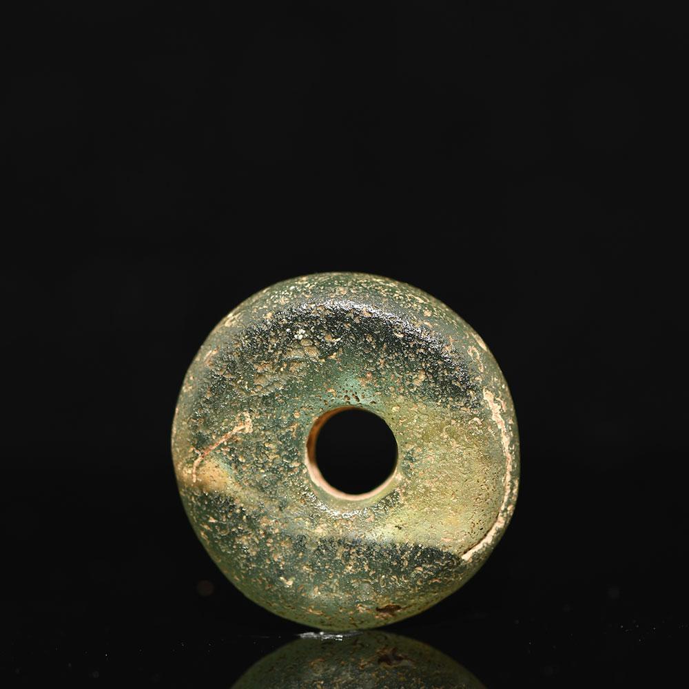 A large Roman Green Glass Bead, ca. 1st - 2nd century CE - ex museum.