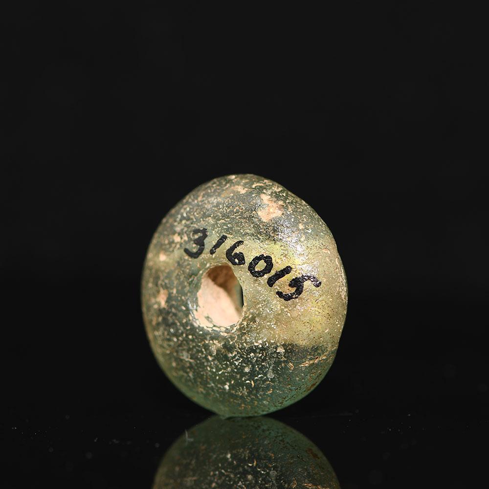 A large Roman Green Glass Bead, ca. 1st - 2nd century CE - ex museum.